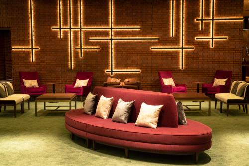 盛冈Art Hotel Morioka的一个带椅子和吊灯的房间的红色沙发