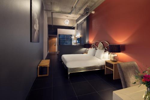 埃因霍温WestCord Hotel Eindhoven的配有一张床和一把椅子的酒店客房