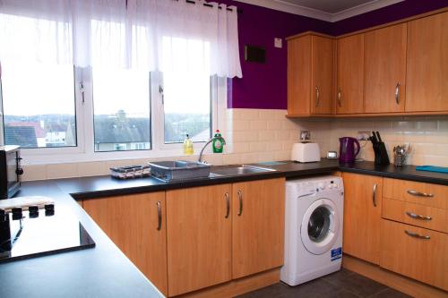 格兰奇茅斯Carvetii - Derwent House - Spacious 2nd floor flat的厨房配有洗衣机和洗衣机。