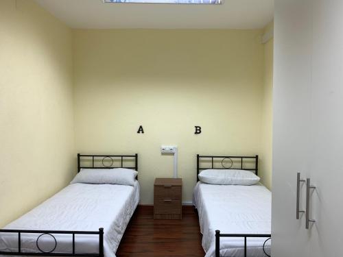 Caboalles de AbajoEl cordal de laciana的白色墙壁客房的两张床