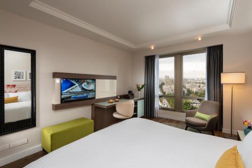 特拉维夫特拉维夫莱昂纳多城市大厦酒店的配有一张床和一张书桌的酒店客房
