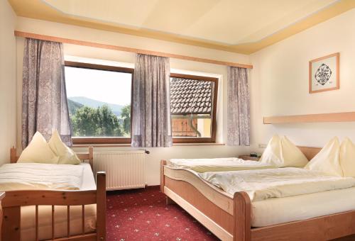 Schöder奈沃特宾馆的一间卧室设有两张床和窗户。