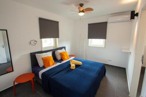克拉伦代克Kas Honkie Tonkie的一间卧室配有蓝色的床和橙色枕头