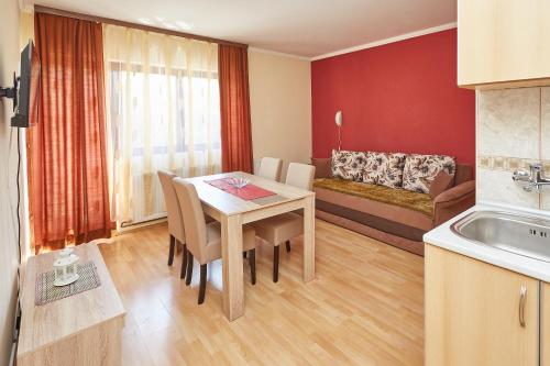 索科矿泉村Apartmani Stojadinović的厨房以及带桌子和沙发的客厅。
