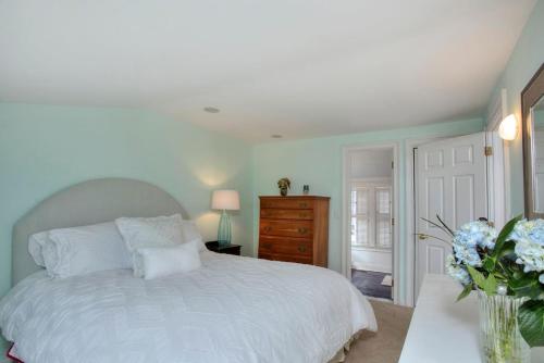 费尔菲尔德Gem by the Sound - Beach Front的卧室配有白色的床和花瓶