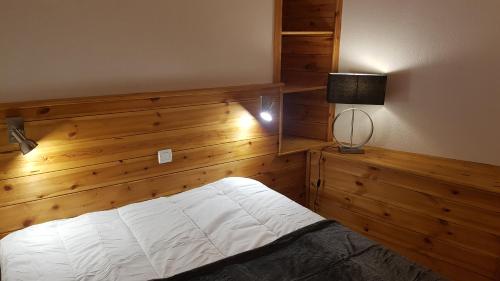 圣沙夫雷Très bel appartement pied de pistes 6 pers Serre Chevalier Chantemerle的一间卧室配有一张木墙床