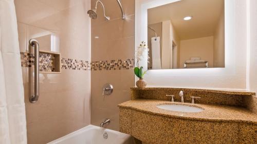 安大略安大略机场贝斯特韦斯特普勒斯酒店的浴室配有盥洗盆、镜子和浴缸