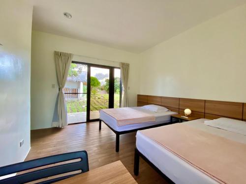 莫阿尔博阿Casa de Moalboal的酒店客房设有两张床和窗户。