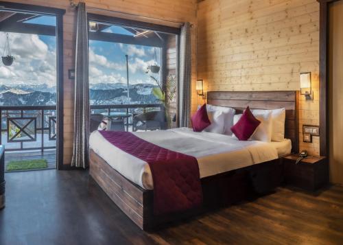 西姆拉Woodays Resort的一间卧室设有一张大床和一个大窗户