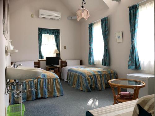 山中湖村Shinkaifujishoen的酒店客房设有两张床和盥洗盆