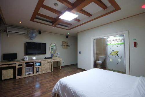 大田Motel Nine的一间卧室配有一张床和一台平面电视