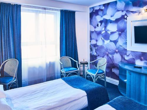 特尔古穆列什Continental Forum Tirgu Mures的酒店客房带一张床、椅子和电视