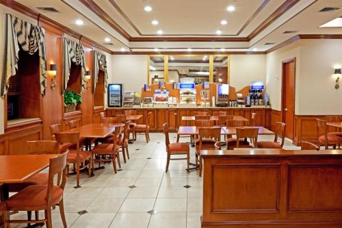 林布鲁克Rockville Centre Hotel的一间带桌椅的餐厅和一间酒吧