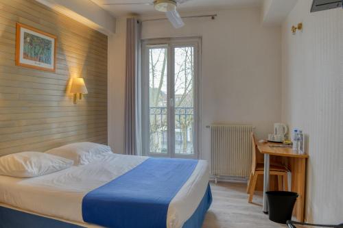 贝尔热拉克Hotel Le Gambetta的一间卧室配有一张床、一张书桌和一个窗户。