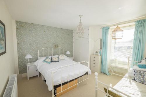 以撒港Trethoway的卧室配有白色的床和窗户。