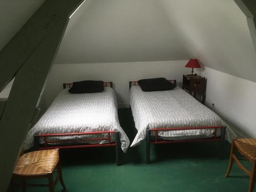 Bosc-Bénard-ComminLA POMMERAIE的阁楼间配有两张床,铺有绿色地毯