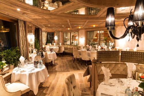 弗林肯贝格思道克度假酒店的餐厅设有白色的桌椅和天花板
