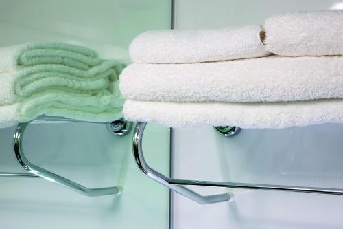 伦敦Snoozebox Olympic Park的浴室毛巾架上的毛巾堆