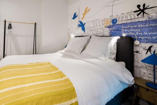 巴黎SUITE APOLLINAIRE : au cœur de la Rive Gauche, neuf, design, 2/4 personnes的卧室配有一张白色大床和黄色毯子