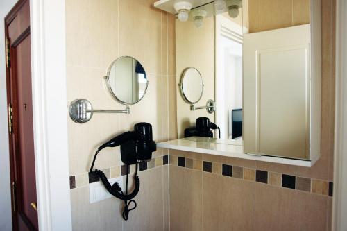 罗塔Apartamentos Costa de la Luz playa的浴室设有两个水槽和两面墙上的镜子