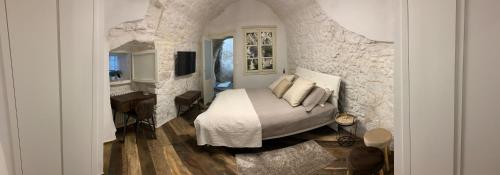 奥斯图尼Panta Rei的一间卧室设有一张床和石墙