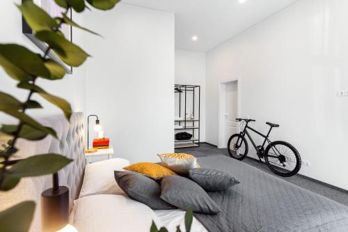 考纳斯Kaunas Garden的客房内的白色沙发、枕头和自行车