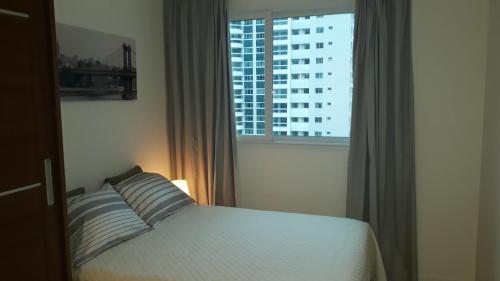 里约热内卢Ilha Pura Barra Temporada的一间卧室设有一张床和一个大窗户