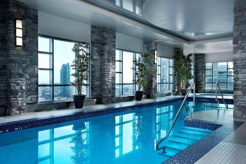 卡尔加里卡尔加里凯悦酒店的一座带窗户的建筑中的游泳池