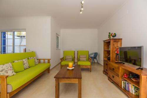 曼塔罗塔Blue Villa by ALGARVEMANTA的客厅配有绿色沙发和电视
