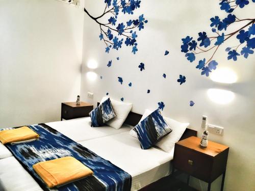 科伦坡Visakha 6的卧室配有一张挂着蓝色鲜花的床。