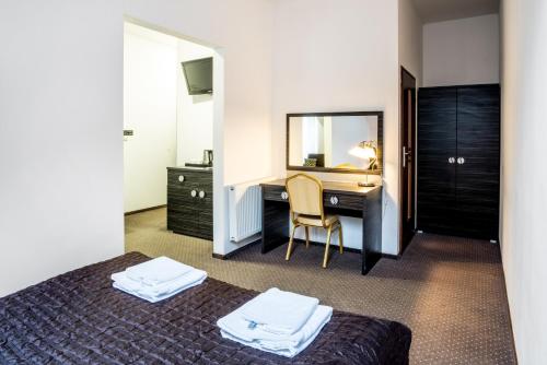 加尔沃林苏尔滨酒店的一间卧室配有一张床和一张带镜子的书桌