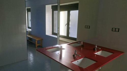 Caboalles de AbajoEl cordal de laciana的浴室设有红色的柜台和3个水槽