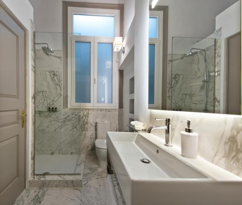 雅典Acropolis TownHouseCo Suites的白色的浴室设有水槽和卫生间。