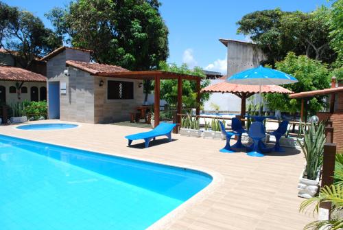 康塞桑达巴拉Hotel Rusticos的一个带蓝色椅子和遮阳伞的游泳池