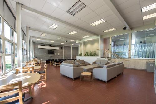 魁北克市拉瓦尔大学公寓酒店的大型客房设有沙发、桌子和椅子。