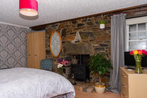 库勒Stravaig B&B的一间卧室设有石墙、一张床和一个壁炉
