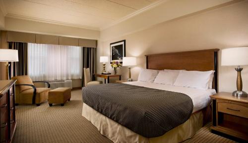 劳伦斯堡Hollywood Casino Lawrenceburg的配有一张床和一把椅子的酒店客房