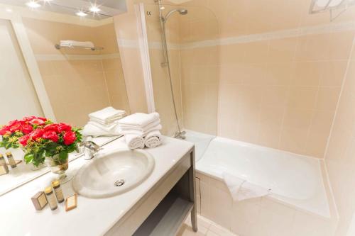 巴黎尚贝雷艾利欧波利斯酒店的浴室配有盥洗盆和浴缸。