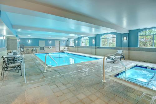 阿弗内尔伍德布里奇快捷假日酒店的大楼内带桌椅的大型游泳池