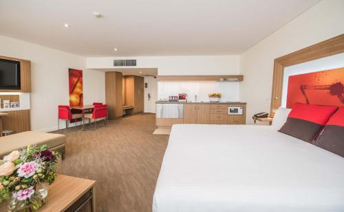 乐蒂山Novotel Sydney West HQ的酒店客房设有一张大床和一个厨房。