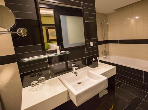马六甲玛扎弗酒店的浴室配有盥洗盆、镜子和浴缸
