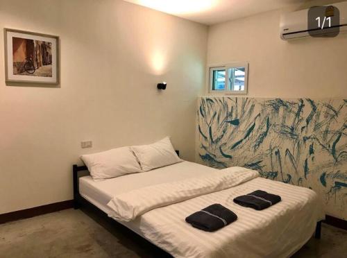 高兰WAKE UP @Lanta Hotel : Cafe的一间卧室配有一张带两张黑色毛巾的床