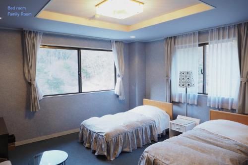 富士河口湖松杰山酒店的酒店客房设有两张床和窗户。