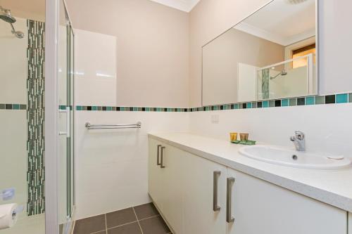 ErldundaErldunda Desert Oaks Resort的带淋浴和盥洗盆的白色浴室