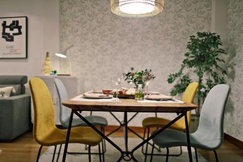 毕尔巴鄂ZUBIGANE apartamento junto a la Ría & Parking的配有黄色椅子的餐桌和用餐室