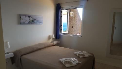 圣地亚哥港Isora Coast的一间卧室配有床和带毛巾的窗户。