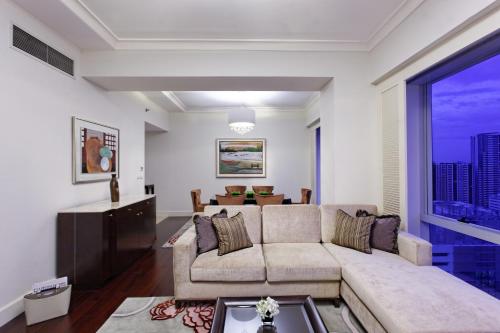 马尼拉Raffles Makati的带沙发和大窗户的客厅