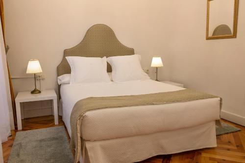 昆卡Hospederia Seminario Conciliar de San Julián的一间卧室配有一张带两盏灯的大型白色床。