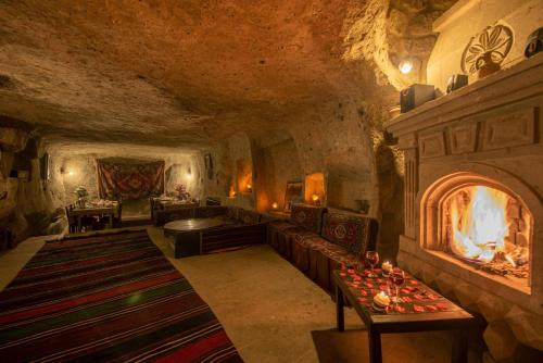 Guzelyurt卡拉曼利大厦酒店的一间位于洞穴内的大型客房,设有壁炉