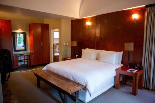 约翰内斯堡十邦帕酒店的卧室配有白色大床和木制床头板